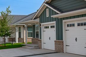 Oklahoma City triplex for rent - A house with a green roof and white garage doors.