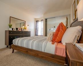 Oklahoma City apartment for rent - A bedroom with a bed, dresser, and mirror.