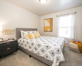 Oklahoma City apartment for rent - A bedroom with a large bed and a painting on the wall.