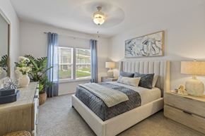 Owasso townhouse for rent - A bedroom with a large bed and a painting on the wall.