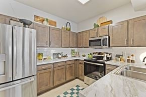 Owasso townhouse for rent - A kitchen with wooden cabinets and a white refrigerator.
