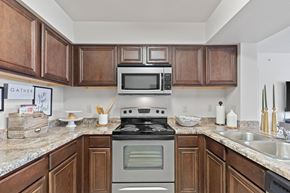 Edmond apartment for rent - A kitchen with a stove top oven and microwave above it.