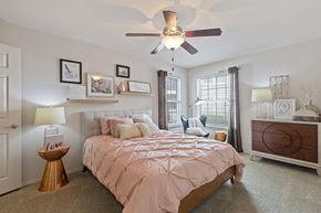 Edmond apartment for rent - A bedroom with a bed, a dresser, and a ceiling fan.