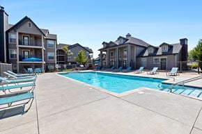 Oklahoma City apartment for rent - A swimming pool surrounded by lounge chairs and buildings.