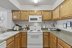 Amarillo apartment for rent - A kitchen with a white stove and wooden cabinets.