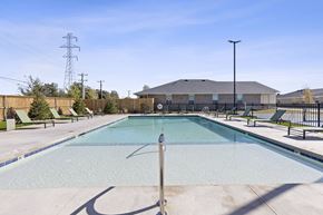 Oklahoma City triplex for rent - A large outdoor swimming pool with a diving board and loungers.