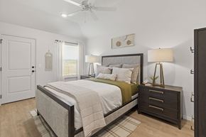 Oklahoma City triplex for rent - A bedroom with a bed, nightstand, and a ceiling fan.