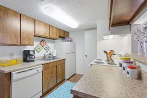 Norman apartment for rent - A kitchen with wooden cabinets and white appliances.
