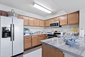 Waco apartment for rent - A kitchen with a white refrigerator and wooden cabinets.