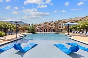 Temple apartment for rent - A pool with blue loungers and a building in the background.