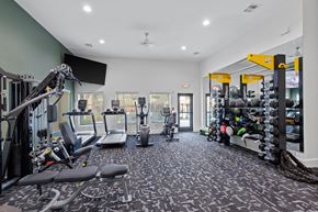 Independence townhouse for rent - A gym with a variety of equipment including a treadmill, weights, and a bench press.
