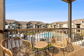 Independence townhouse for rent - Two wicker chairs on a balcony overlooking a pool.