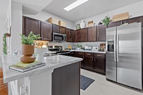 Independence townhouse for rent - A modern kitchen with dark brown cabinets and a white island.