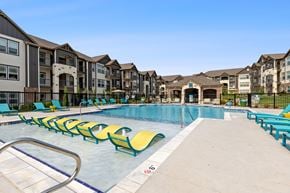 Kansas City apartment for rent - A swimming pool with yellow chairs and a metal ladder.