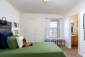 El Paso apartment for rent - A bedroom with a green bedspread and a window with curtains.