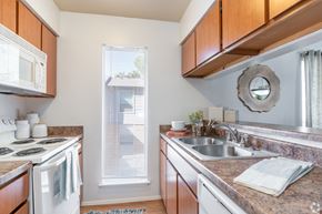 El Paso apartment for rent - A kitchen with a white stove top oven and a white microwave.