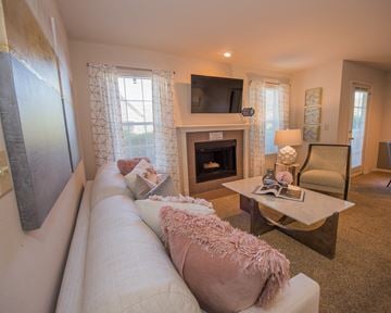 Wichita apartment for rent - A living room with a pink couch and a fireplace.