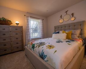 Wichita apartment for rent - A bedroom with a large bed and a window with curtains.