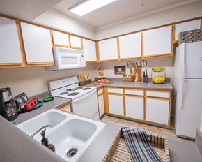 Wichita apartment for rent - A kitchen with white cabinets and a white refrigerator.
