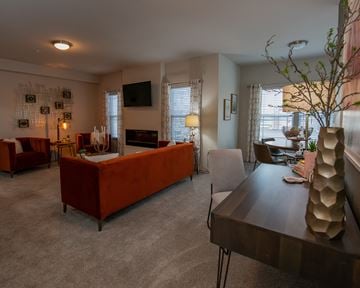 Oklahoma City apartment for rent - A living room with a red couch and a television on the wall.