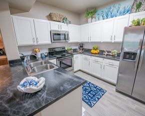 Oklahoma City apartment for rent - A kitchen with a black counter top and white cabinets.