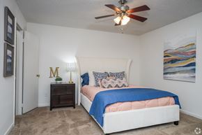 Ridgeland apartment for rent - A bedroom with a bed, a ceiling fan, and a painting on the wall.