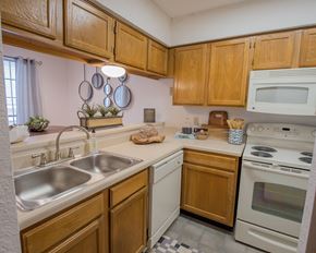 Oklahoma City apartment for rent - A kitchen with wooden cabinets and a white oven.
