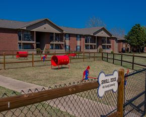 Oklahoma City apartment for rent - A playground area with a sign that says "Small Dogs" in front of a building.