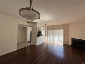 Los Angeles apartment for rent - Living room with wood flooring kitchen, a fireplace, balcony and light fixture.