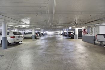 A parking garage with several cars parked.