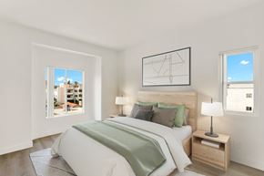 Los Angeles apartment for rent - A bedroom with a large bed and a window overlooking a cityscape.