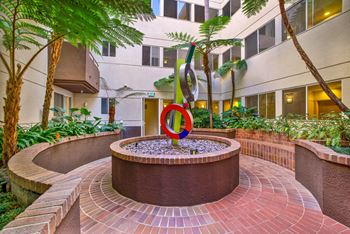 A circular brick patio with a fountain in the middle