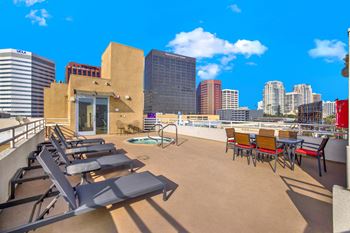 A rooftop patio with chairs and a table