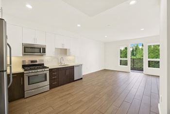 A kitchen with wooden floors and stainless steel appliances