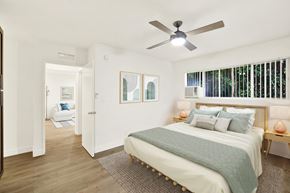 Los Angeles apartment for rent - A bedroom with a bed, a ceiling fan, and a window with blinds at Wooster Encore Apartments, Los Angeles, 90035