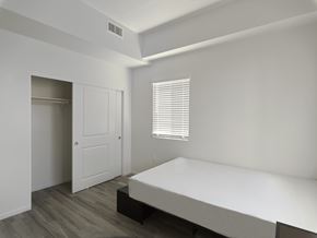 Murrieta apartment for rent - A white bedroom with a bed, dresser, and window.