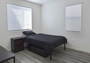Buena Park apartment for rent - A bedroom with a bed, nightstand, and window with blinds.