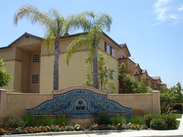 Santa Fe Springs apartment for rent - a building with palm trees and a sign in front of it