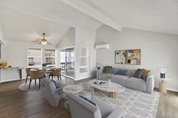 Kent apartment for rent - A modern living room with a grey sofa, a coffee table, and a dining table set up.