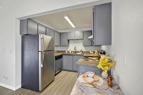 Kent apartment for rent - A modern kitchen with a stainless steel refrigerator and a table set for two.