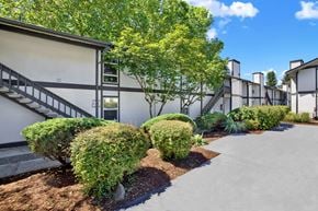 Kent apartment for rent - A building with a staircase and a tree in front.