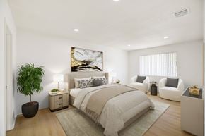 Upland apartment for rent - Furnished bedroom with neutral bedding and seating area at Coventry Square Apartments, Upland