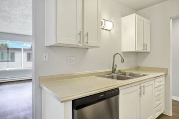 Bellevue apartment for rent - A kitchen with white cabinets and a beige countertop.
