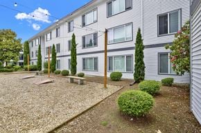 Bellevue apartment for rent - A building with grey siding and a gravel area in front.