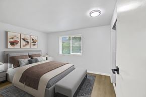 Seattle apartment for rent - A bedroom with a bed, pillows, a blanket, a nightstand, a lamp, a window with blinds, a rug, a picture on the wall, and a door.