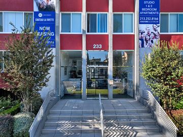 Los Angeles apartment for rent - The front of a building with a red awning and a sign that says "Studio 1 & 2 Bedroom Apartments".