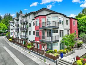 Redmond apartment for rent - A row of multi-story apartment buildings with balconies and flower pots on the steps.