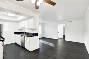 Burbank apartment for rent - A spacious kitchen with white cabinets and black countertops. at Elmwood Gardens, California, 91502