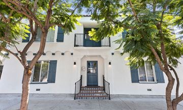 Los Angeles apartment for rent - the front of a white house with a blue door and trees