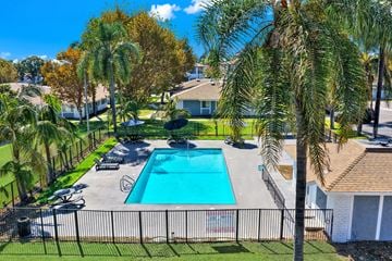 Upland apartment for rent - A pool surrounded by a fence and palm trees.